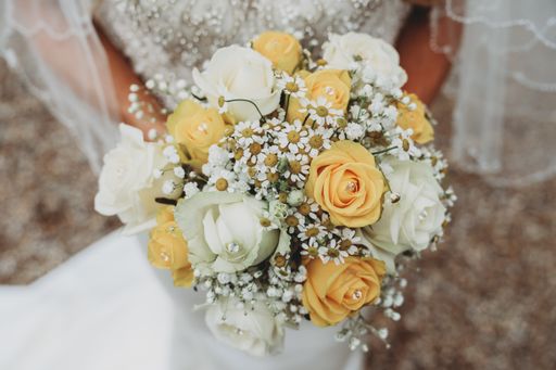 A beautiful scenery of a bride wearing a wedding dress holding her traditional bouquet