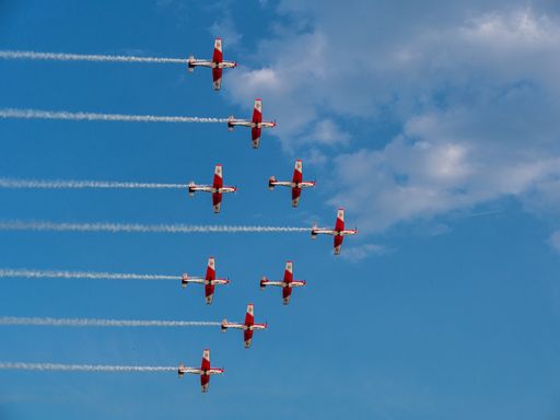 The red jets performing an airshow while leaving white tracks in the sky