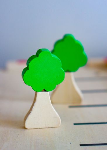A selective focus shot of a miniature wooden tree toy with blocks on a wooden table