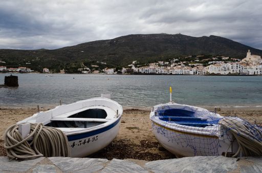 A view of two wooden boats on the shore near the famous statue of Salvador Dali Cadaques in Spain