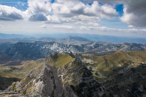 An aerial shot of the Durmitor mountains under the blue sky and white clouds in Montenegro