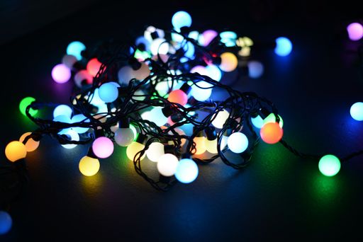 A closeup shot of a Christmas colorful lights on a reflective table surface