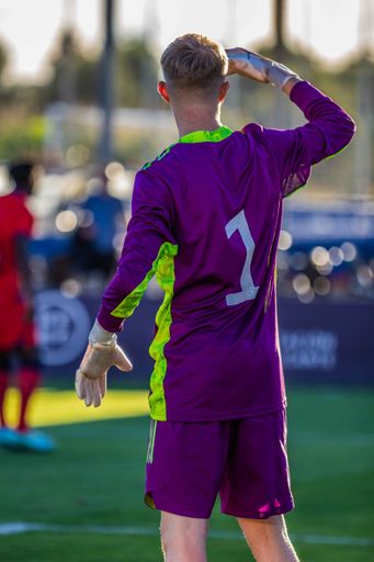 A back view of a young goalkeeper in a field