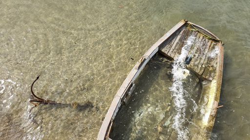 A high angle shot of an old and cracked boat in the water