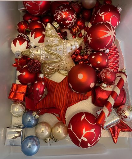 A high angle vertical shot of a colorful shiny Christmas tree ornaments and balls in a plastic box