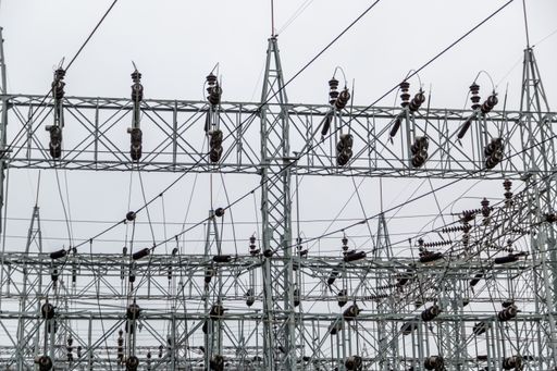 A low angle shot of high voltage powerlines on a gloomy day background