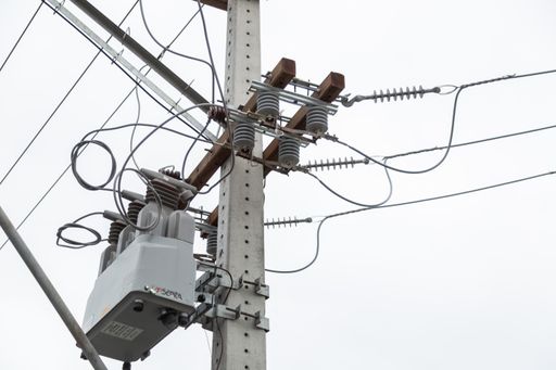 A low angle shot of powerlines and a transmission on a gloomy day background