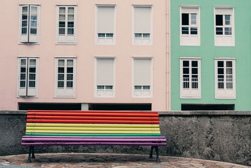 A colorful wooden bench near an old building