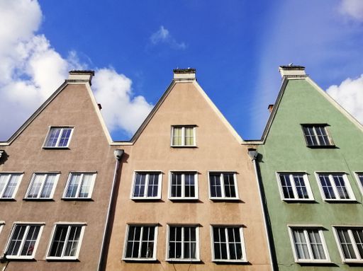 A low angle shot of the colorful houses in Gdansk, Poland with thin clouds background