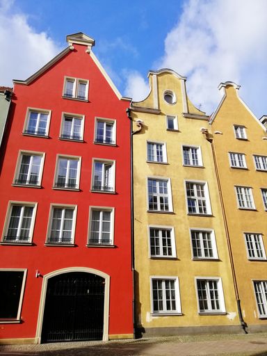 A vertical shot of traditional colorful buildings in the old town of Gdansk, Poland under a cloudy sky