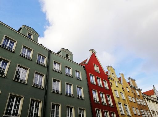 A low angle shot of typical colorful buildings in the old town of Gdansk, Poland under a cloudy sky