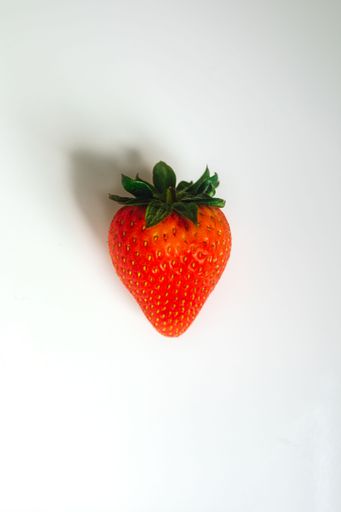 single strawberry fruit on white table