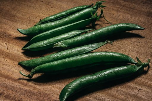 A high angle shot of fresh green peas on the wooden table