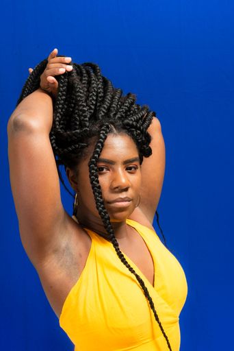Young woman wearing colorful long clothes over blue background. Natural expression.