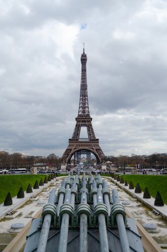 A vertical shot of the Eiffel tower against a cloudy sky in Paris, France