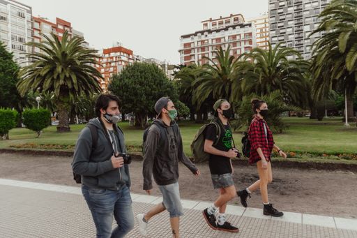 A group of young cool friends wearing medical masks and walking around