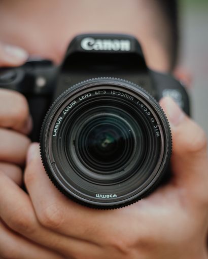 A closeup of a person taking a picture with a Canon digital camera
