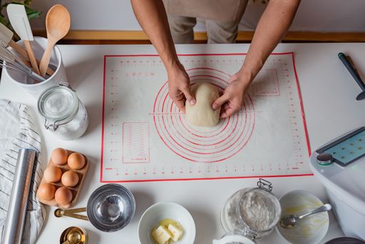 A top view shot of hands of Hispanic baker making cinnamon rolls