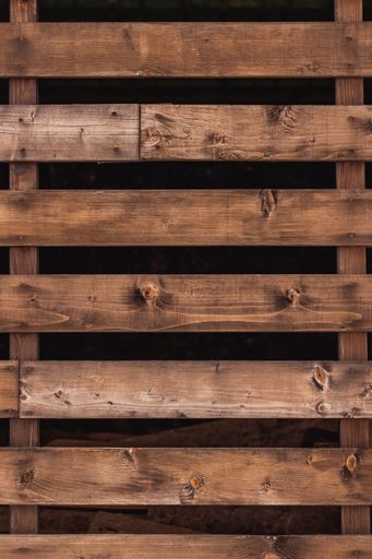 A closeup of wooden plank fences against a blurry background - a cool picture for wallpapers
