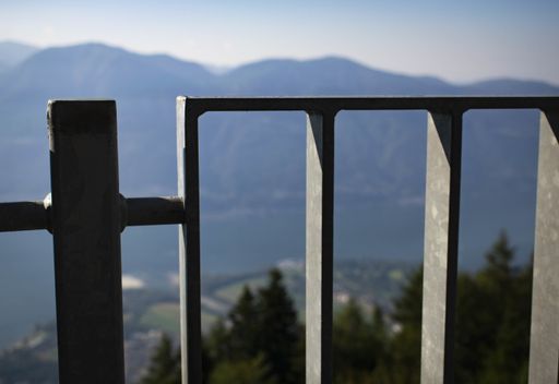 A closeup shot of an iron fence with blurry mountains behind