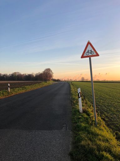 A vertical shot of the bicycle sign near the rural road in Germany