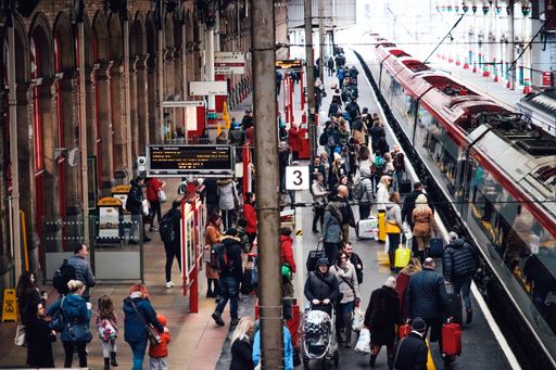 A capture of a train station with crowds of people waiting to get on the train in Lake District