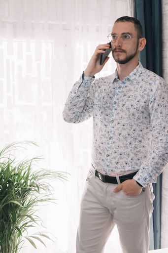 A vertical shot of a standing man making a call with copy space on the left side
