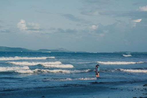 A beautiful shot of two people enjoying sea waves during a daytime