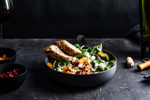 A salad with lamb's lettuce, pomegranat seeds, goat cheese, mandarine, spring onion and red wine