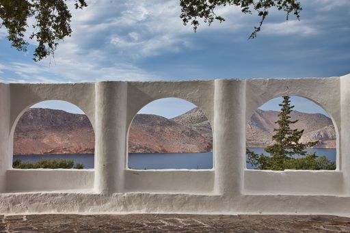 A beautiful shot of an old white fence with arches in Symi island, Greece