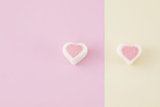 A top view closeup of colorful marshmallows isolated on a pinkand yellow background