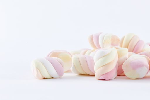 A top view closeup of colorful marshmallows isolated on a white background