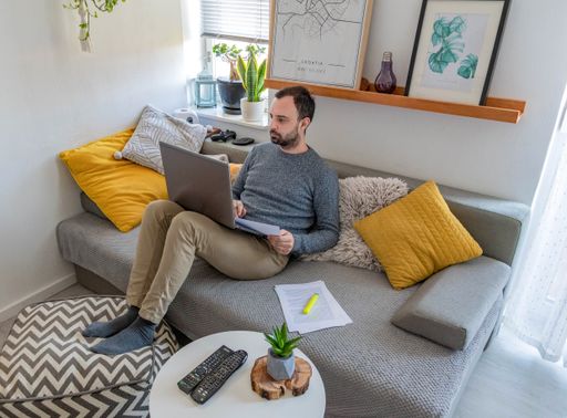 A Caucasian male working with a laptop at home