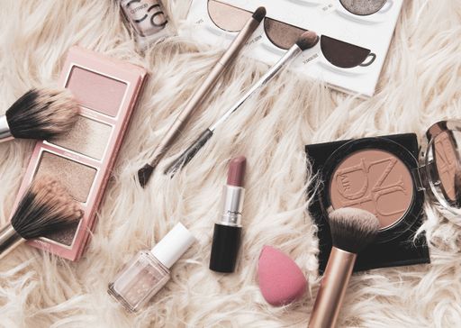 Make up accessories on fluffy background. Lipstick, nail polish, cosmetics.