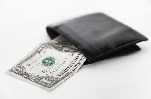 A black wallet with cash dollar isolated on white background