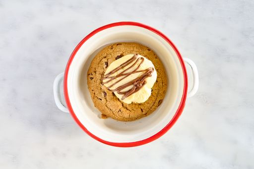 A top view closeup of a chocolate chip cookie with ice cream