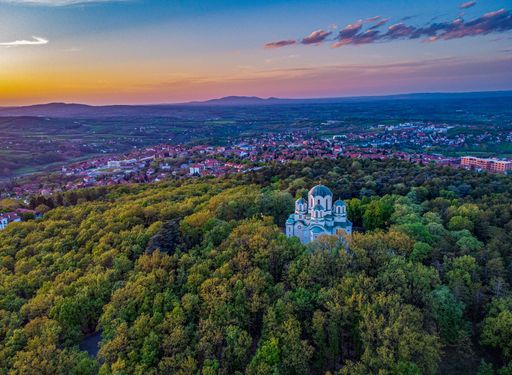 An aerial shot of St George Church in the middle of a forest in Oplenac, Topola, Serbia