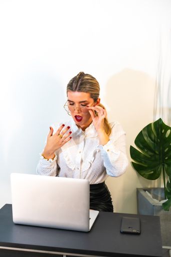A closeup of a young indignant businesswoman working on the laptop