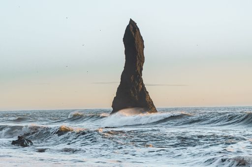An iconic seastack in front of the world-famous Reynisfjara Black sand beach in Reynisdrangar, Iceland