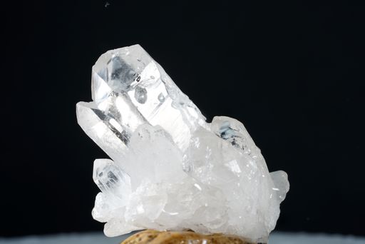 A closeup shot of a  druse of transparent rock crystals isolated on a dark background