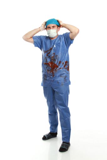 A vertical shot of a young male doctor full of blood after surgery isolated on white background