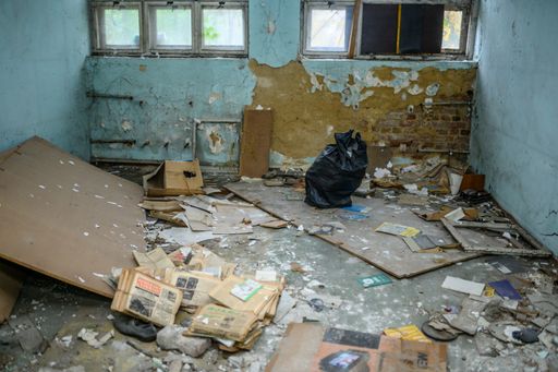 A closeup of a scattered abandoned room with rubbish on the ground