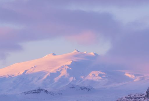 A beautiful sunrise scene of the Snaefellsjokull volcano by snow in the pink clouds in Iceland
