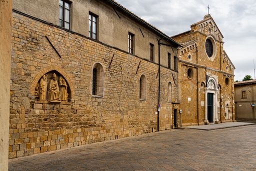 The ancient Cathedral of Santa Maria Assunta under cloudy sky in the old historic town of Volterra, Italy