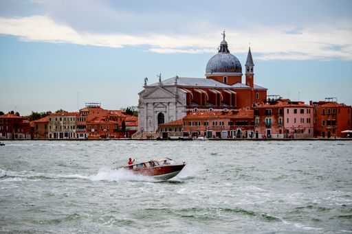 A picturesque view of the classic Venetian streets of Italy, with colorful architecture and winding canals creating a unique atmosphere