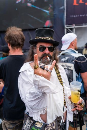 A vertical shot of an older male rocking out at the Brutal Assault 2022 festival in Jaromer