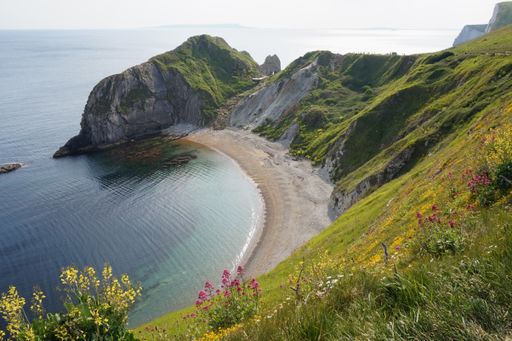 The beautiful view of the green mountains and hills near the sea in Durdle Door, Wareham, UK