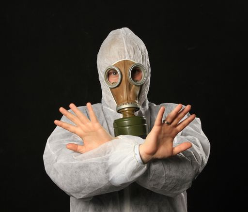 A male in full protective clothing wearing a gas mask