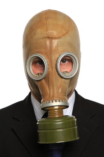 A vertical shot of a man with a suit-wearing a gas mask on a white background