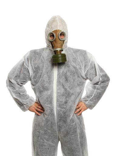 A person in a hazmat suit with a gas mask isolated on a white background